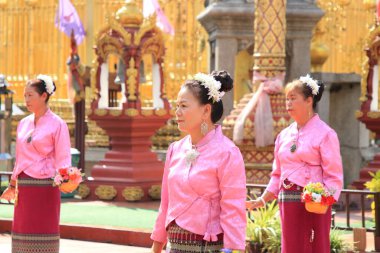 LAMPHUN -THAILAND: November 11, 2023:  Beautiful senior women perform an ancient Thai dance showing dancing in buddhist religious ceremony in TWat Phra That Haripunchai Woramahawihan. Thai nail dance with flower.