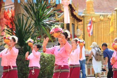 LAMPHUN -THAILAND: November 11, 2023:  Beautiful senior women perform an ancient Thai dance showing dancing in buddhist religious ceremony in TWat Phra That Haripunchai Woramahawihan. Thai nail dance with flower.