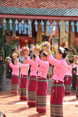 LAMPHUN -THAILAND: November 11, 2023:  Beautiful senior women perform an ancient Thai dance showing dancing in buddhist religious ceremony in TWat Phra That Haripunchai Woramahawihan. Thai nail dance with flower.