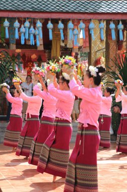 LAMPHUN -THAILAND: November 11, 2023:  Beautiful senior women perform an ancient Thai dance showing dancing in buddhist religious ceremony in TWat Phra That Haripunchai Woramahawihan. Thai nail dance with flower.