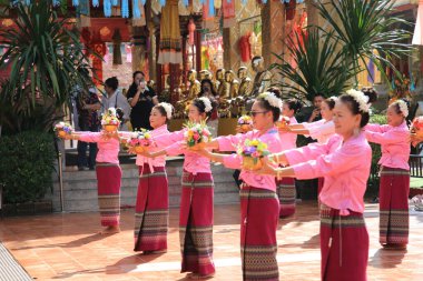 LAMPHUN -THAILAND: November 11, 2023:  Beautiful senior women perform an ancient Thai dance showing dancing in buddhist religious ceremony in TWat Phra That Haripunchai Woramahawihan. Thai nail dance with flower.