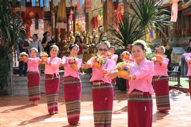 LAMPHUN -THAILAND: November 11, 2023:  Beautiful senior women perform an ancient Thai dance showing dancing in buddhist religious ceremony in TWat Phra That Haripunchai Woramahawihan. Thai nail dance with flower.