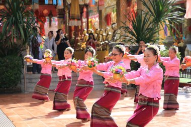 LAMPHUN -THAILAND: November 11, 2023:  Beautiful senior women perform an ancient Thai dance showing dancing in buddhist religious ceremony in TWat Phra That Haripunchai Woramahawihan. Thai nail dance with flower.