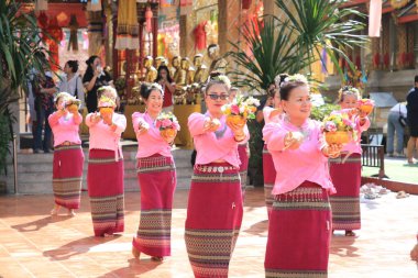 LAMPHUN -THAILAND: November 11, 2023:  Beautiful senior women perform an ancient Thai dance showing dancing in buddhist religious ceremony in TWat Phra That Haripunchai Woramahawihan. Thai nail dance with flower.