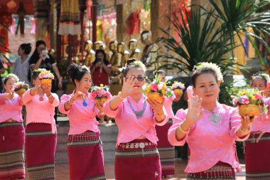 LAMPHUN -THAILAND: November 11, 2023:  Beautiful senior women perform an ancient Thai dance showing dancing in buddhist religious ceremony in TWat Phra That Haripunchai Woramahawihan. Thai nail dance with flower.