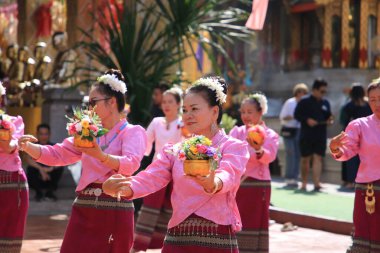 LAMPHUN -THAILAND: November 11, 2023:  Beautiful senior women perform an ancient Thai dance showing dancing in buddhist religious ceremony in TWat Phra That Haripunchai Woramahawihan. Thai nail dance with flower.