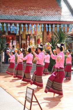 LAMPHUN -THAILAND: November 11, 2023:  Beautiful senior women perform an ancient Thai dance showing dancing in buddhist religious ceremony in TWat Phra That Haripunchai Woramahawihan. Thai nail dance with flower.