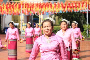 LAMPHUN -THAILAND: November 11, 2023:  Beautiful senior women perform an ancient Thai dance showing dancing in buddhist religious ceremony in TWat Phra That Haripunchai Woramahawihan. Thai nail dance with flower.