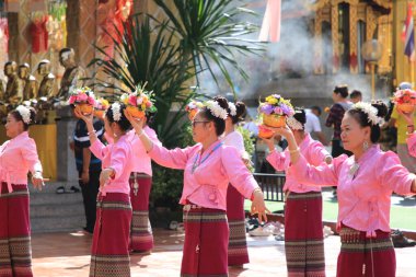LAMPHUN -THAILAND: November 11, 2023:  Beautiful senior women perform an ancient Thai dance showing dancing in buddhist religious ceremony in TWat Phra That Haripunchai Woramahawihan. Thai nail dance with flower.