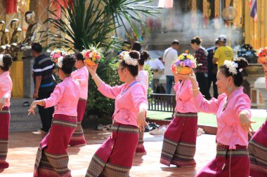LAMPHUN -THAILAND: November 11, 2023:  Beautiful senior women perform an ancient Thai dance showing dancing in buddhist religious ceremony in TWat Phra That Haripunchai Woramahawihan. Thai nail dance with flower.