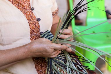 Taylandlı bir kadının eli bambudan bir sepet örüyor. İnsanlar bambudan geleneksel bir sepet örüyorlar.