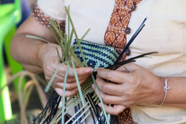 Taylandlı bir kadının eli bambudan bir sepet örüyor. İnsanlar bambudan geleneksel bir sepet örüyorlar.