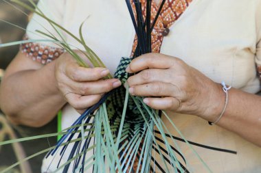 Taylandlı bir kadının eli bambudan bir sepet örüyor. İnsanlar bambudan geleneksel bir sepet örüyorlar.