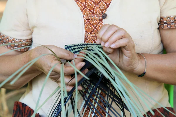 Taylandlı bir kadının eli bambudan bir sepet örüyor. İnsanlar bambudan geleneksel bir sepet örüyorlar.