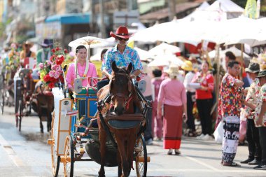 Lampang, Tayland, 13 Nisan 2024: Lanna tarzı geleneksel kostümlü güzel kadın ve Hansom erkek oyuncuları Salung Luang Klong Yai Festivali 'ni kutlamak için düzenlenen Songkran geçit törenine katıldılar.