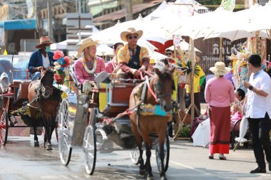 Lampang, Tayland, 13 Nisan 2024: Lanna tarzı geleneksel kostümlü güzel kadın ve Hansom erkek oyuncuları Salung Luang Klong Yai Festivali 'ni kutlamak için düzenlenen Songkran geçit törenine katıldılar.