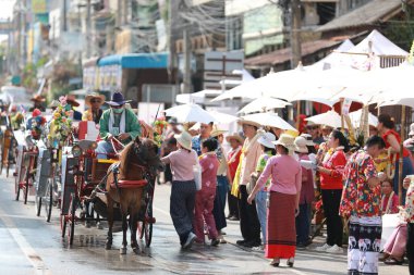 Lampang, Tayland, 13 Nisan 2024: Lanna tarzı geleneksel kostümlü güzel kadın ve Hansom erkek oyuncuları Salung Luang Klong Yai Festivali 'ni kutlamak için düzenlenen Songkran geçit törenine katıldılar.