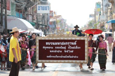 Lampang, Tayland, 13 Nisan 2024: Lanna tarzı geleneksel kostümlü güzel kadın ve Hansom erkek oyuncuları Salung Luang Klong Yai Festivali 'ni kutlamak için düzenlenen Songkran geçit törenine katıldılar.