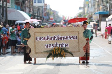 Lampang, Tayland, 13 Nisan 2024: Lanna tarzı geleneksel kostümlü güzel kadın ve Hansom erkek oyuncuları Salung Luang Klong Yai Festivali 'ni kutlamak için düzenlenen Songkran geçit törenine katıldılar.