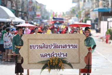 Lampang, Tayland, 13 Nisan 2024: Lanna tarzı geleneksel kostümlü güzel kadın ve Hansom erkek oyuncuları Salung Luang Klong Yai Festivali 'ni kutlamak için düzenlenen Songkran geçit törenine katıldılar.