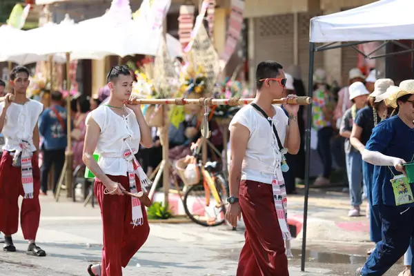 Lampang, Tayland, 13 Nisan 2024: Lanna tarzı geleneksel kostümlü güzel kadın ve Hansom erkek oyuncuları Salung Luang Klong Yai Festivali 'ni kutlamak için düzenlenen Songkran geçit törenine katıldılar.