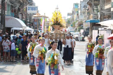 Lampang, Tayland, 13 Nisan 2024: Lanna tarzı geleneksel kostümlü güzel kadın ve Hansom erkek oyuncuları Salung Luang Klong Yai Festivali 'ni kutlamak için düzenlenen Songkran geçit törenine katıldılar.
