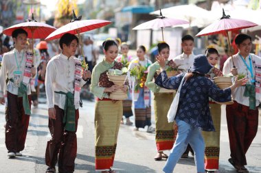 Lampang, Tayland, 13 Nisan 2024: Lanna tarzı geleneksel kostümlü güzel kadın ve Hansom erkek oyuncuları Salung Luang Klong Yai Festivali 'ni kutlamak için düzenlenen Songkran geçit törenine katıldılar.
