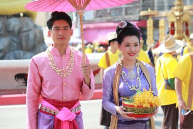 Lampang, Tayland, 13 Nisan 2024: Lanna tarzı geleneksel kostümlü güzel kadın ve Hansom erkek oyuncuları Salung Luang Klong Yai Festivali 'ni kutlamak için düzenlenen Songkran geçit törenine katıldılar.