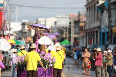 Lampang, Tayland, 13 Nisan 2024: Lanna tarzı geleneksel kostümlü güzel kadın ve Hansom erkek oyuncuları Salung Luang Klong Yai Festivali 'ni kutlamak için düzenlenen Songkran geçit törenine katıldılar.