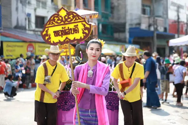 Lampang, Tayland, 13 Nisan 2024: Lanna tarzı geleneksel kostümlü güzel kadın ve Hansom erkek oyuncuları Salung Luang Klong Yai Festivali 'ni kutlamak için düzenlenen Songkran geçit törenine katıldılar.