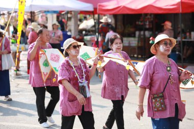 Lampang, Tayland, 13 Nisan 2024: Salung Luang Klong Yai Festivali onuruna düzenlenen Songkran geçit töreninde, geleneksel Lanna kıyafeti giymiş yakışıklı kadın oyuncular ve Hansom erkek aktörler yer aldı..