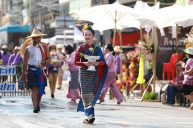 Lampang, Tayland, 13 Nisan 2024: Salung Luang Klong Yai Festivali onuruna düzenlenen Songkran geçit töreninde, geleneksel Lanna kıyafeti giymiş yakışıklı kadın oyuncular ve Hansom erkek aktörler yer aldı..