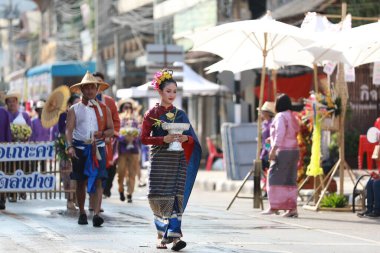 Lampang, Tayland, 13 Nisan 2024: Salung Luang Klong Yai Festivali onuruna düzenlenen Songkran geçit töreninde, geleneksel Lanna kıyafeti giymiş yakışıklı kadın oyuncular ve Hansom erkek aktörler yer aldı..
