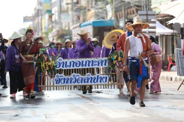 Lampang, Tayland, 13 Nisan 2024: Salung Luang Klong Yai Festivali onuruna düzenlenen Songkran geçit töreninde, geleneksel Lanna kıyafeti giymiş yakışıklı kadın oyuncular ve Hansom erkek aktörler yer aldı..