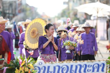 Lampang, Tayland, 13 Nisan 2024: Salung Luang Klong Yai Festivali onuruna düzenlenen Songkran geçit töreninde, geleneksel Lanna kıyafeti giymiş yakışıklı kadın oyuncular ve Hansom erkek aktörler yer aldı..