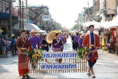 Lampang, Tayland, 13 Nisan 2024: Salung Luang Klong Yai Festivali onuruna düzenlenen Songkran geçit töreninde, geleneksel Lanna kıyafeti giymiş yakışıklı kadın oyuncular ve Hansom erkek aktörler yer aldı..