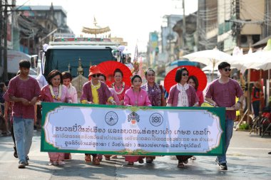 Lampang, Tayland, 13 Nisan 2024: Salung Luang Klong Yai Festivali onuruna düzenlenen Songkran geçit töreninde, geleneksel Lanna kıyafeti giymiş yakışıklı kadın oyuncular ve Hansom erkek aktörler yer aldı..