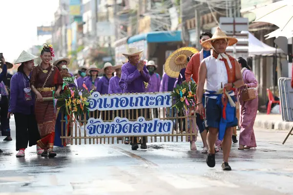 Lampang, Tayland, 13 Nisan 2024: Salung Luang Klong Yai Festivali onuruna düzenlenen Songkran geçit töreninde, geleneksel Lanna kıyafeti giymiş yakışıklı kadın oyuncular ve Hansom erkek aktörler yer aldı..