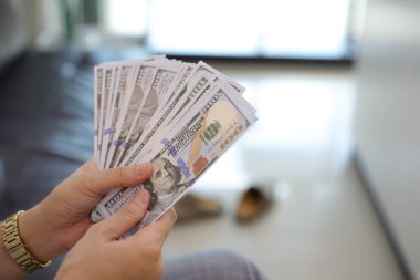 Para elinde, el ele tutuşan dolar banknotları. 