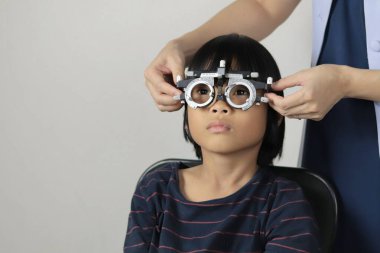 Çocuk göz muayenesi, çocuk göz testi optik, Phoropter 'ın hastanede çocuk göz testi. 