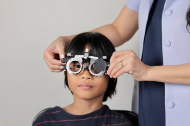 Çocuk göz muayenesi, çocuk göz testi optik, Phoropter 'ın hastanede çocuk göz testi. 