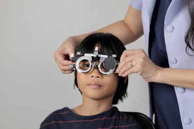 Çocuk göz muayenesi, çocuk göz testi optik, Phoropter 'ın hastanede çocuk göz testi. 