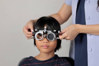 Çocuk göz muayenesi, çocuk göz testi optik, Phoropter 'ın hastanede çocuk göz testi. 