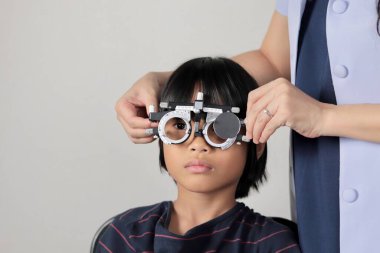 Çocuk göz muayenesi, çocuk göz testi optik, Phoropter 'ın hastanede çocuk göz testi. 