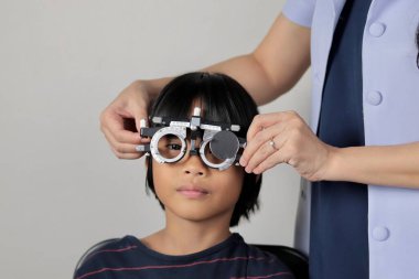 Çocuk göz muayenesi, çocuk göz testi optik, Phoropter 'ın hastanede çocuk göz testi. 