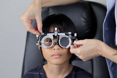 Çocuk göz muayenesi, çocuk göz testi optik, Phoropter 'ın hastanede çocuk göz testi. 