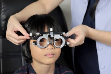 Çocuk göz muayenesi, çocuk göz testi optik, Phoropter 'ın hastanede çocuk göz testi. 