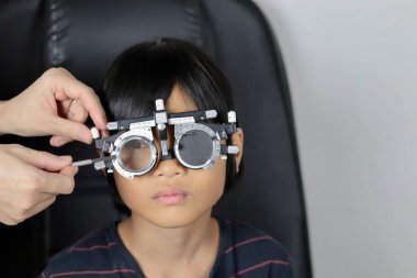 Çocuk göz muayenesi, çocuk göz testi optik, Phoropter 'ın hastanede çocuk göz testi. 