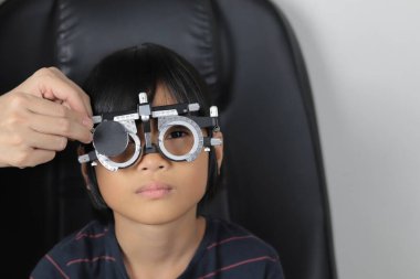 Çocuk göz muayenesi, çocuk göz testi optik, Phoropter 'ın hastanede çocuk göz testi. 