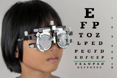 Çocuk göz muayenesi, çocuk göz testi optik, Phoropter 'ın hastanede çocuk göz testi. 